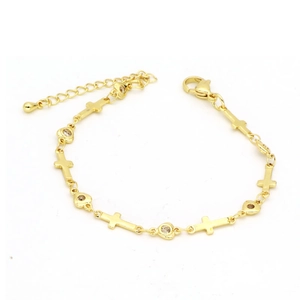 Detail einer Goldkette Armband mit Kreuzanhängern, Kristallcharms und Karabinerverschluss
