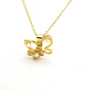Detailed close-up of golden butterfly pendant with white pearls and sparkling crystals