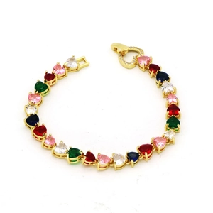 Detail of gold tennis bracelet featuring colorful heart-shaped stones and a crystal clasp