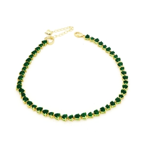 Detailed macro view of gold heart-shaped green zircon tennis chain with lobster clasp closure