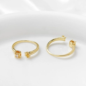 Dettaglio macro di basi per anelli regolabili placcate oro 14k con fiori e zirconi per DIY