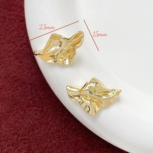 Makroaufnahme vergoldeter, unregelmäßiger Blatt-Ohrringe mit den Maßen 23 mm x 15 mm