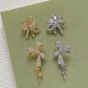 Macro detail of gold and silver bow-shaped jewelry charms with micro-pave cubic zirconia