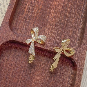 Detailed macro view of gold-plated bow earrings with micro-paved cubic zirconia stones