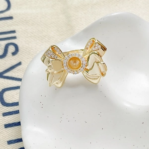 Detailed macro view of an 18k gold plated bow-shaped DIY ring setting with pavé zircon stones