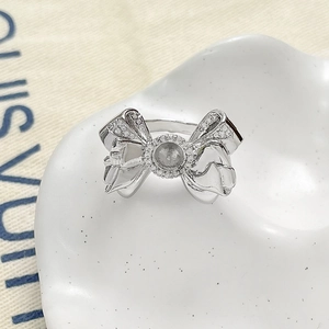 Detailed view of silver bow-shaped ring setting with micro-pave zircons for DIY jewelry