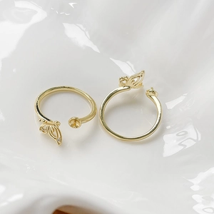 Vista macro di due anelli a farfalla placcati oro 18k con basi regolabili per perle DIY