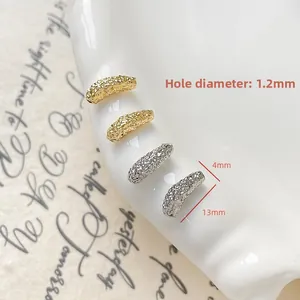 Macro shot of 13mm gold and silver textured tube beads for DIY jewelry making