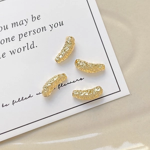 Detail view of 18k gold plated hammered texture curved tube beads for DIY jewelry making