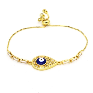 Detail of gold evil eye bracelet with blue enamel, zircon inlay and adjustable box chain