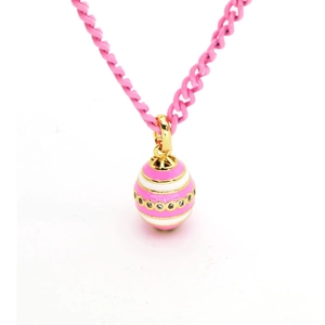 Macro detail of pink and white striped enamel egg pendant on golden cuban link chain