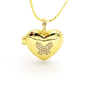 Detailed view of golden heart locket necklace with pavé crystal butterfly and bead chain