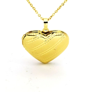 Polished gold heart locket necklace with striped texture on a delicate chain