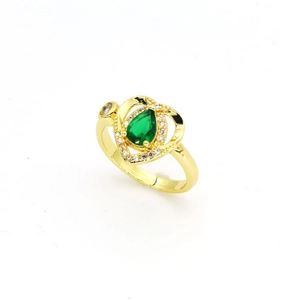 Détail d'une bague coeur dorée avec un zircon vert poire et de petits cristaux blancs.