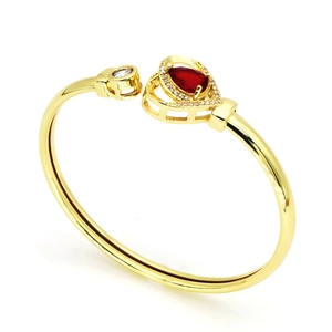 Détail exquis d'une pierre précieuse rouge en forme de cœur sur un bracelet doré