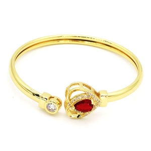 Vue détaillée d'un élégant bracelet jonc en cœur doré avec zircons rouges et blancs.