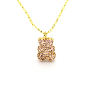 Detailansicht einer goldenen Kugelkette mit einem rosa kristallbesetzten Bärenanhänger