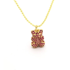 Detailaufnahme einer goldenen Kugelkette mit einem teddybär-anhänger und roten zirkonia