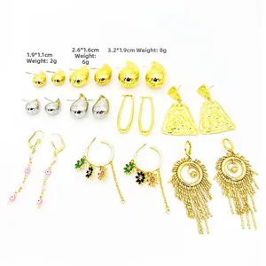 Colección de pendientes de gota dorados y tachuelas irregulares sobre fondo blanco liso