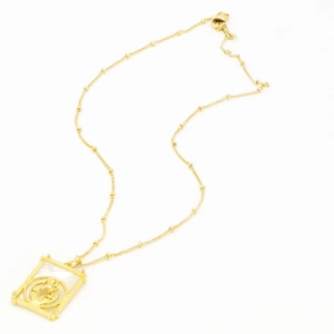 Détail du collier doré vintage avec pendentif rectangulaire en nacre et relief religieux