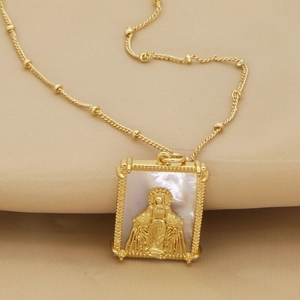 Détail du collier doré avec pendentif rectangulaire en nacre et médaille de Vierge Marie