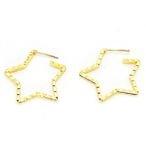 Gros plan de boucles d'oreilles en forme d'étoile plaquées or 18k avec fini texturé