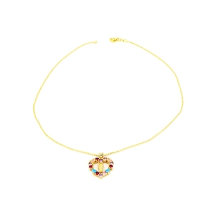 Dettaglio della collana con ciondolo a cuore con gemme colorate e intaglio religioso