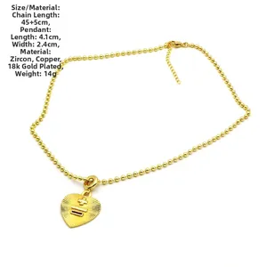 Détail du pendentif cœur plaqué or 18k avec zircon et croix gravée sur chaîne à billes