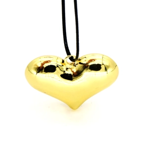 Collar con colgante de corazón 3D dorado pulido con cordón negro sobre fondo blanco