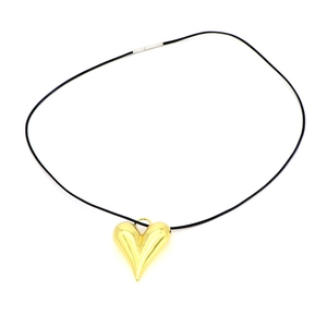 Detalle de colgante de corazón dorado pulido con cordón negro y hebilla plateada