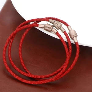 Vue détaillée du bracelet en cuir tressé rouge avec des fermoirs magnétiques en bronze