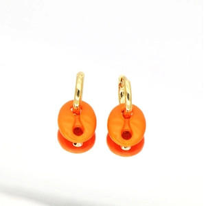 Moderne goldene Creolen mit leuchtend orangefarbenen Anhängern im Kaffeebohnen-Design