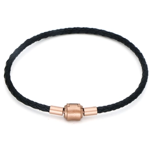 Détail du bracelet tressé en cuir noir avec un fermoir magnétique en or rose poli