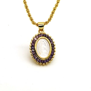 Detailed close-up of gold rope chain necklace with purple zircon and shell cameo pendant