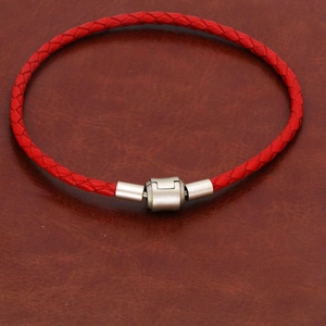 Bracelet tressé en cuir rouge avec fermoir magnétique argenté sur fond en cuir