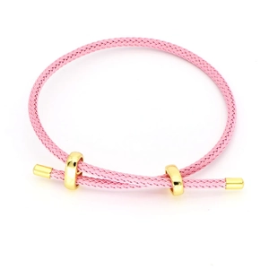 Nahaufnahme von rosa geflochtenem Armband mit verstellbaren Goldschiebern auf weißem Grund