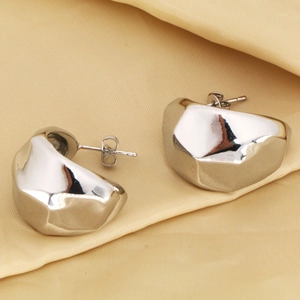 Detalle macro de pendientes geométricos de gota de plata con acabado metálico pulido