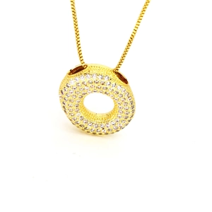 Detailaufnahme einer goldenen Halskette mit einem zirkonbesetzten Donut-Kreis-Anhänger