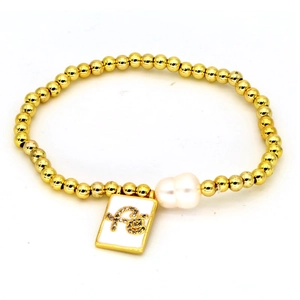 Golden beaded bracelet featuring baroque pearl and square 'Fe' letter pendant on white background