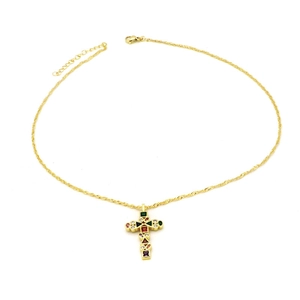 Close-up of vintage gold twisted chain necklace with colorful zircon cross pendant
