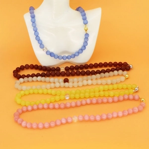 Detail view of multi-color agate and cat eye stone beaded necklaces with metal clasps