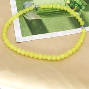 Detail of yellow agate beaded necklace with silver magnetic clasp on fabric