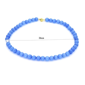 Detail of blue cat eye stone bead necklace with a 36cm length and golden magnetic clasp