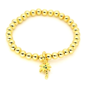Gold beaded bracelet with palm tree pendant and green zircon accents on white background