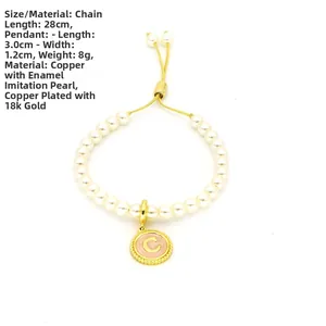 Close-up of adjustable imitation pearl bracelet with a pink enamel letter C pendant