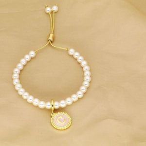 Detail of beaded pearl bracelet with adjustable gold slide clasp and letter C pendant