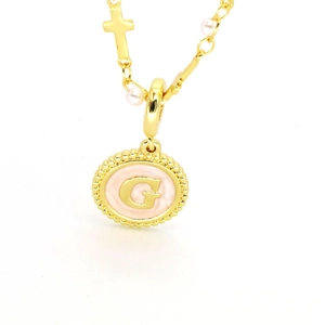 Détail du collier lettre G doré avec fond rose, breloques croix et perles fines