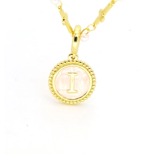 Détail du pendentif lettre I en or avec émail rose et collier chaîne de perles