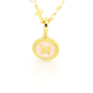 Détail du collier doré avec initiale N, émail rose, perle blanche et petit pendentif croix