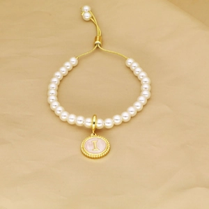Adjustable pearl bracelet with a pink gold-edged round pendant featuring the letter I